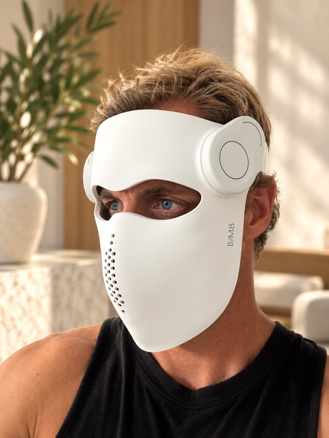 Man wearing the white LUM8 ProLaser Face Mask at home